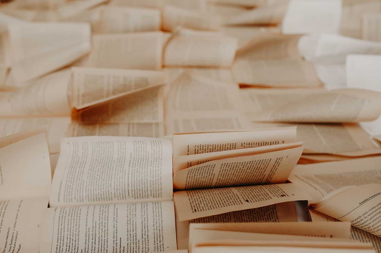 Geöffnete Bücher verteilt auf dem Boden.