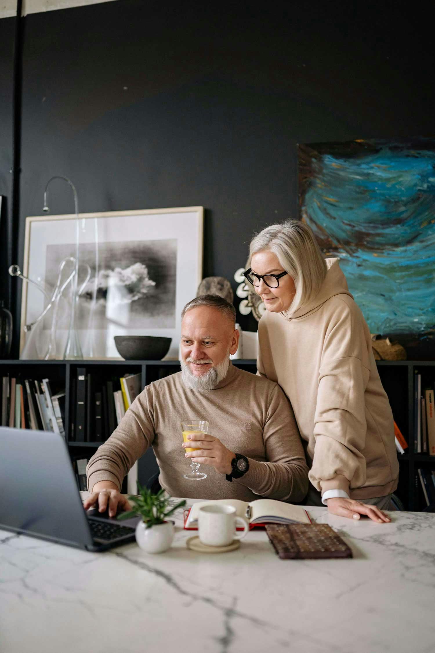 Eine Frau und ein Mann schauen in ein Laptop und schauen sich die lohnt-es-sich.de Webseite an.