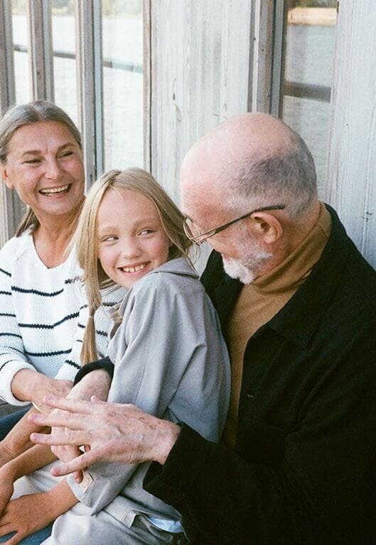 Großmutter, Großvater und Enkelkind verbringen Zeit miteinander und lachen gemeinsam